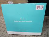 an open box of robot vacuum cleaner sitting on a tiled floor