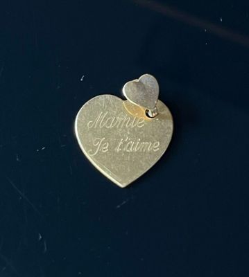 a gold heart with a small heart on top of it