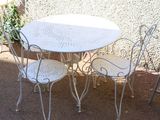 une table et des chaises blanches à l'extérieur, sur une terrasse
