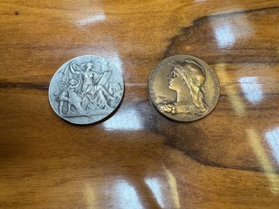 two coins sitting on a wooden table next to each other