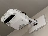 a projector hanging from the ceiling in a small room