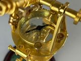 a gold clock on a stand with a green marble base