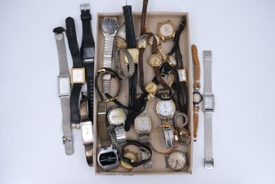 une boîte remplie de montres et d'autres montres posées sur une table