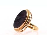 an image of a gold ring with a black stone in the center