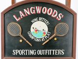 une enseigne sur laquelle est inscrit « Langwood's » et sur laquelle figurent deux raquettes de tennis