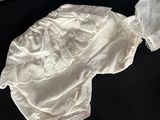 two white and pink baby clothes on a black table