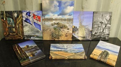de nombreux tableaux posés sur une table noire, sur lesquels figurent des images