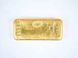 a close up of a gold bar on a white surface