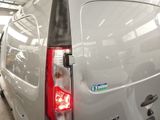 a silver van parked in a garage with its lights on