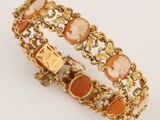 un gros plan d'un bracelet en or orné de pierres orange