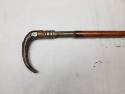 un gros plan d'une canne avec un manche en bois posée sur une surface blanche