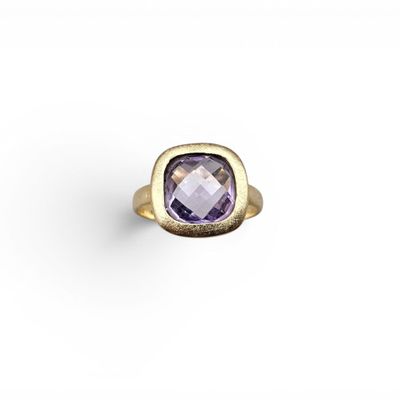 une bague en or sertie d'une pierre d'améthorate au centre