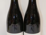 deux bouteilles de vin posées l'une à côté de l'autre sur une table