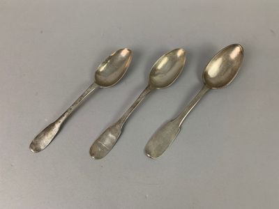 three silver spoons sitting on top of a table next to each other