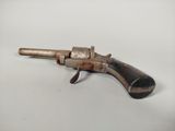 a small toy gun with a wooden handle on a white surface
