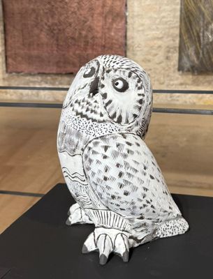 a white owl sitting on top of a black table
