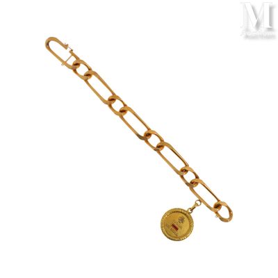 Gros plan sur un bracelet en chaîne en or sur lequel se trouve une pièce de monnaie