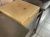 plans de travail en acier inoxydable dans une cuisine professionnelle, avec une cuisinière en arrière-plan
