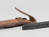 a small knife and a leather sheath on a white surface