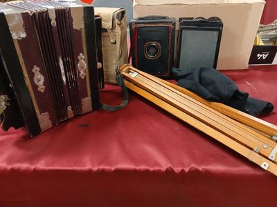 a red table with a bunch of old accordions on it