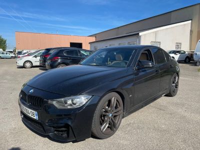 the black bmw car is parked in a parking lot with other cars