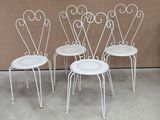 three white metal chairs sitting next to each other in front of a wall