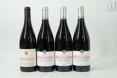 quatre bouteilles de vin sont alignées sur une surface blanche