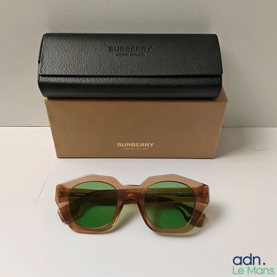 une paire de lunettes de soleil posée sur une table à côté d'une boîte