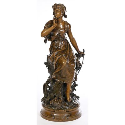 une statue antique en bronze représentant une femme avec un oiseau sur l'épaule