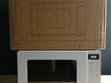 two microwaves sitting on top of each other on a table