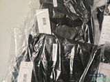a lot of black clothing wrapped in plastic bags