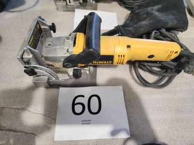 une ponceuse électrique jaune et noire posée par terre