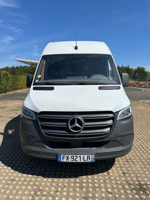 a white van parked in a parking lot with a blue sky in the background