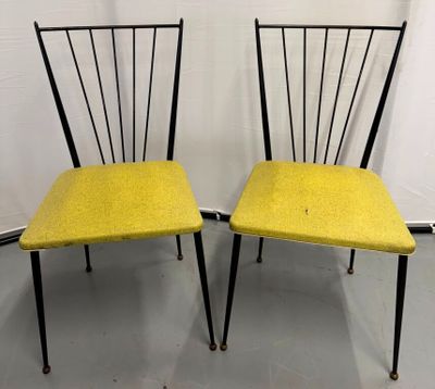 une paire de chaises jaunes aux pieds noirs et à l'assise jaune