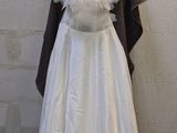 a dress on a mannequin stand in front of a brick wall