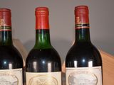 three bottles of wine sitting on a wooden table