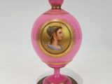 un vase rose orné d'une image représentant une femme