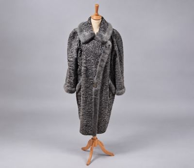 un manteau de fourrure gris et noir posé sur un pied de mannequin