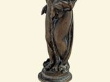 statue en bronze représentant une femme tenant un enfant dans ses bras, posée sur un socle