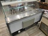 tables and chairs in a restaurant with a glass display case