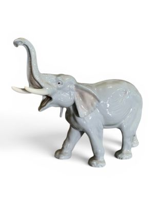 une figurine d'éléphant posée sur une surface blanche