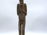 l'image d'une statue en bois représentant un homme avec un chapeau sur la tête