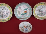 three plates and a bowl are sitting on a red cloth