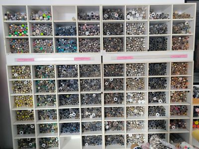 a lot of buttons on the shelves in the craft room
