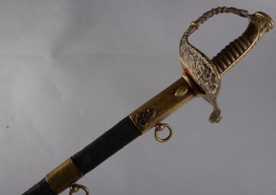 une épée à la poignée dorée sur fond blanc