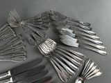 a lot of silverware on a table with a knife and fork