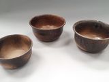 trois bols marron posés les uns à côté des autres sur une table blanche