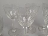 six clear wine glasses sitting on top of a table next to each other