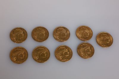 un groupe de six pièces d'or posées sur une surface blanche