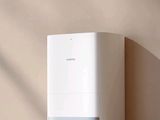 un purificateur d'air blanc posé sur une table en bois